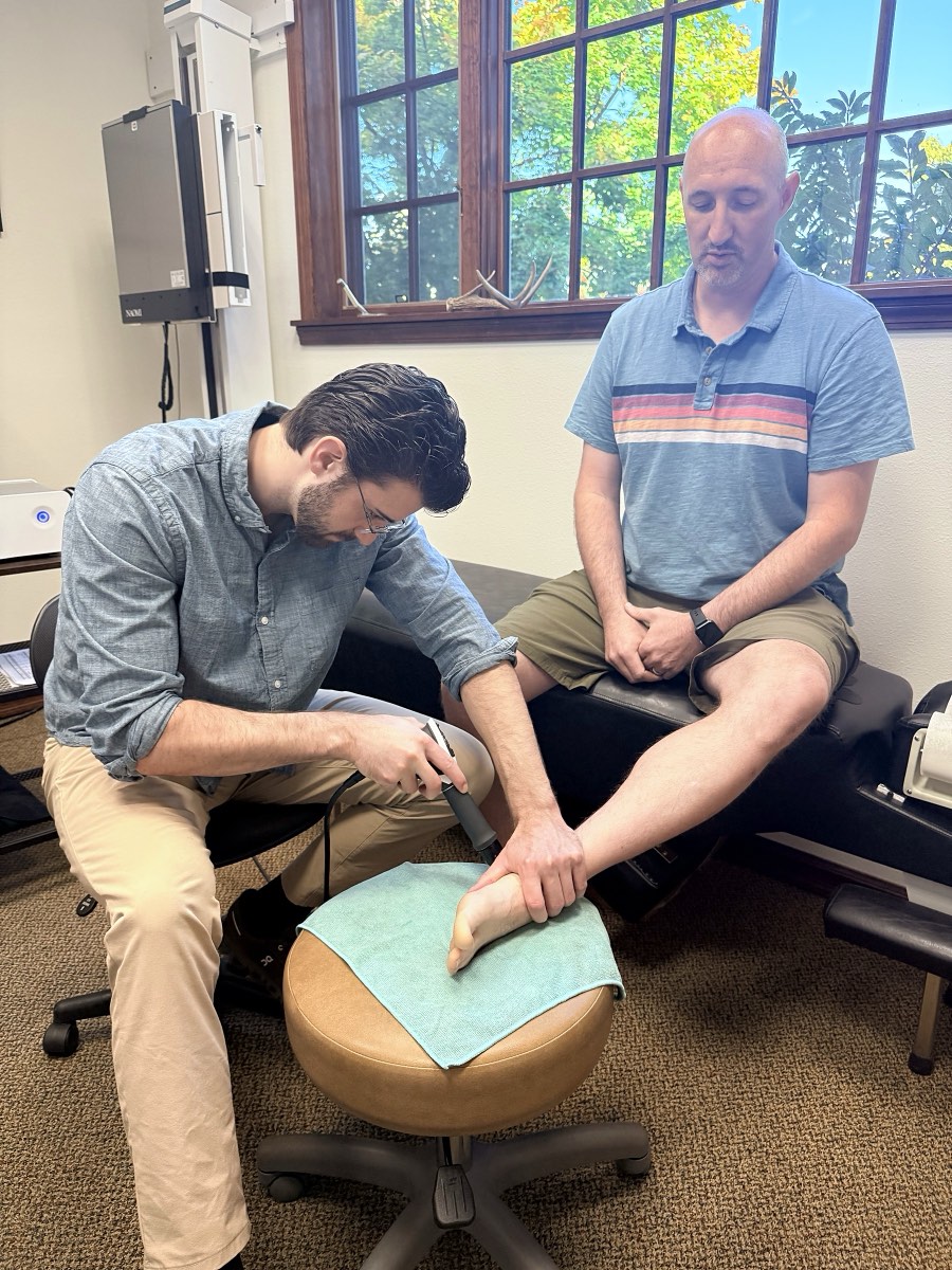 Dr. Coltin Golden treating a patient's heel with shockwave therapy for plantar fasciitis